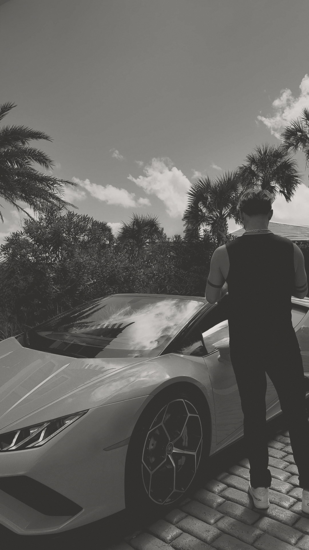 Trevor Thomas photographed outdoors beside a car, soft black and white