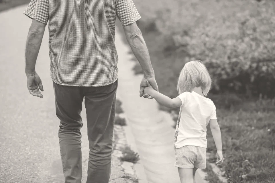 A father walking hand in hand with his child
