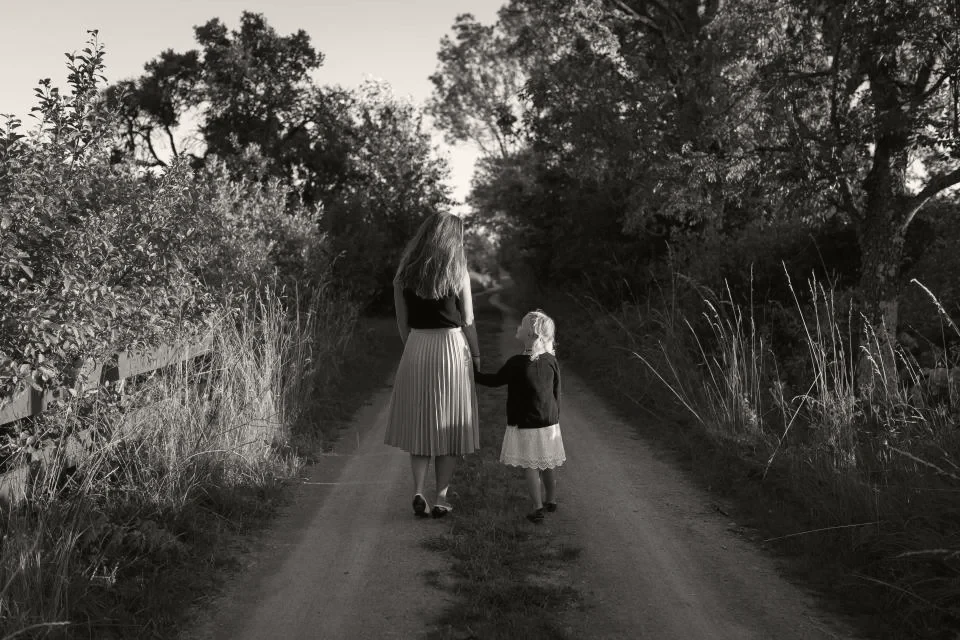 An adult and a child walking a quiet path together