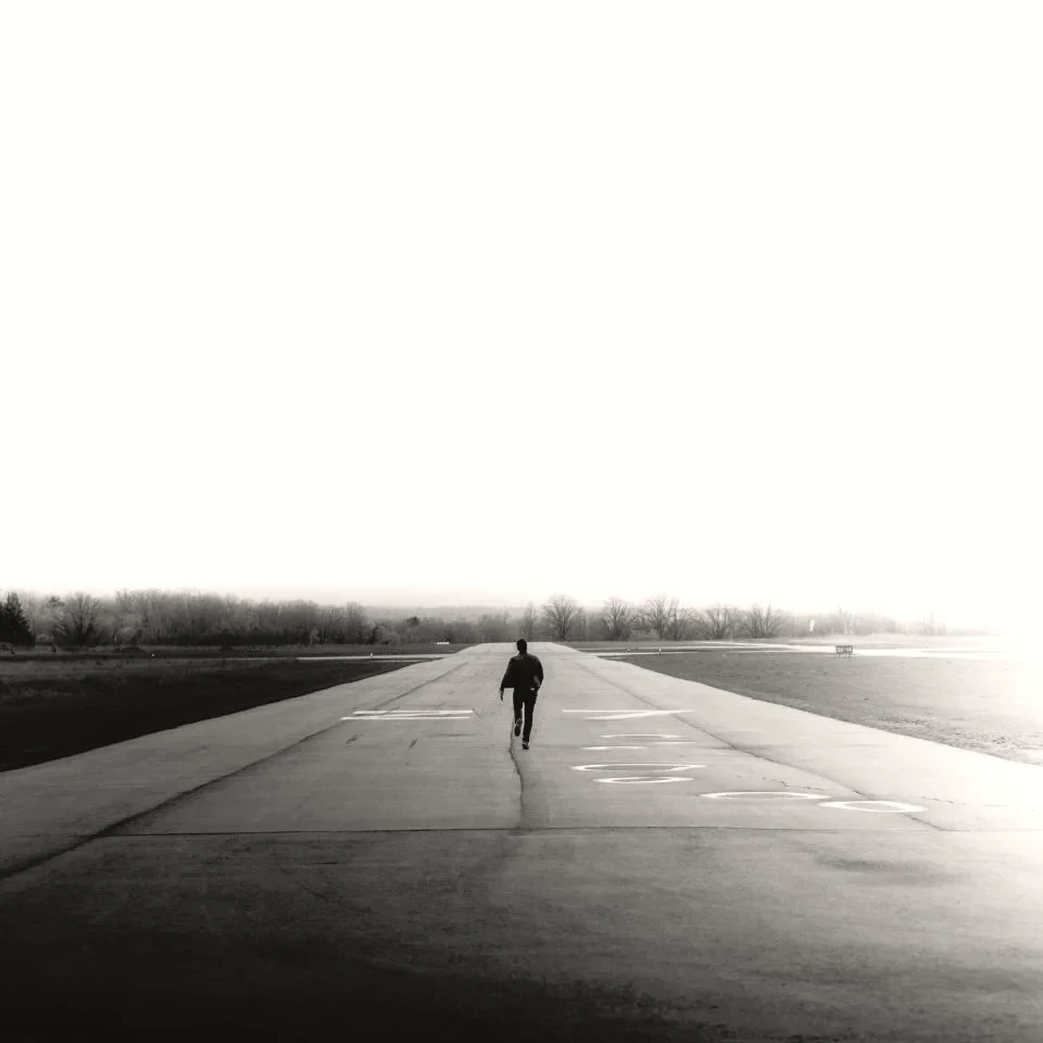 A person running alone on an open road at first light