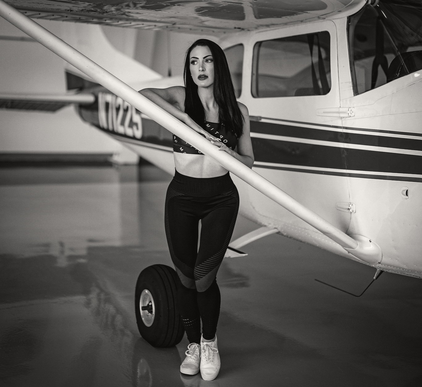 OPTIMISM. archive Plate 01, 2022 — Hangar. Performance bra and seamless legging, shot against the wing.