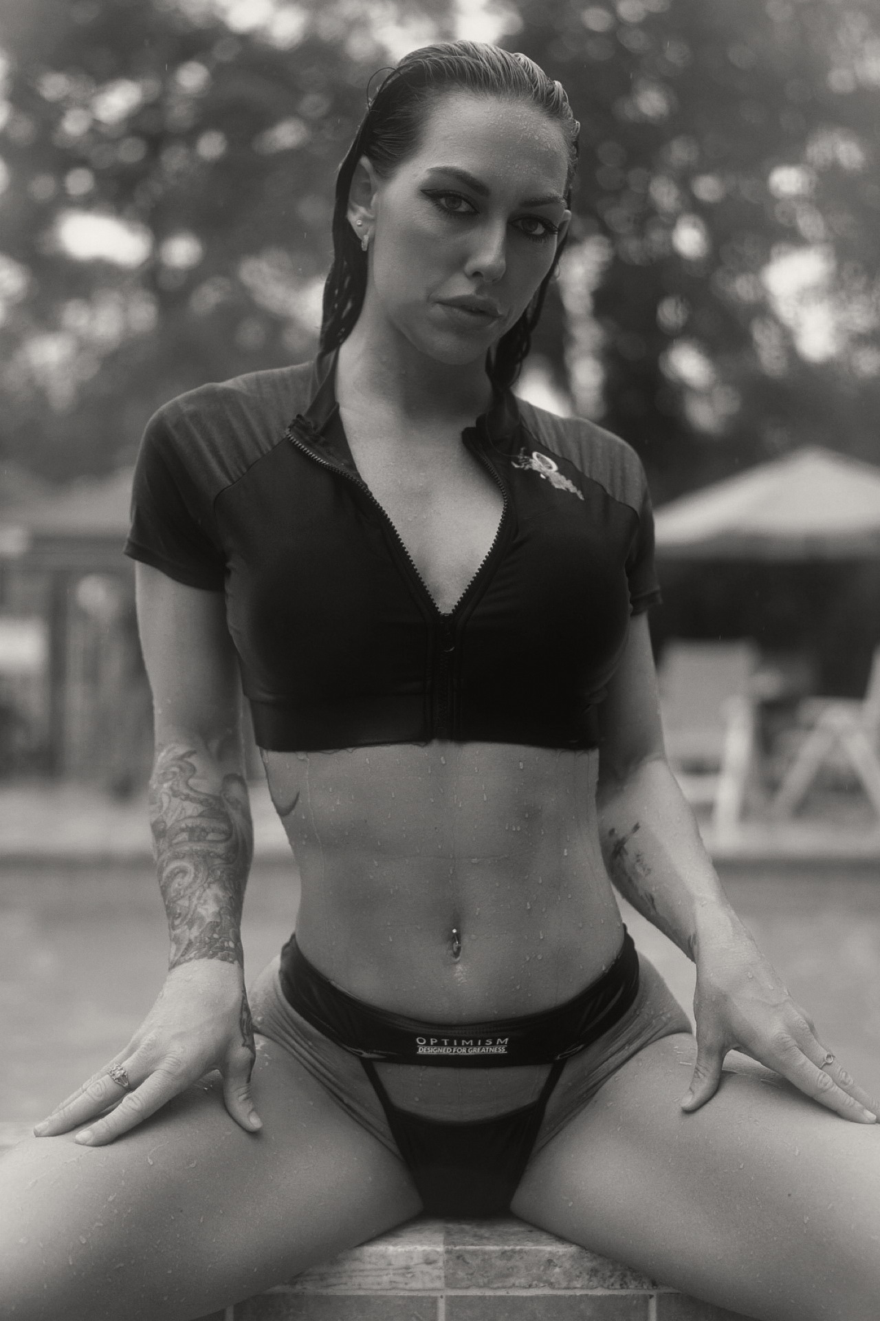 OPTIMISM. archive — Zip crop rash guard, poolside. Rain on the frame.