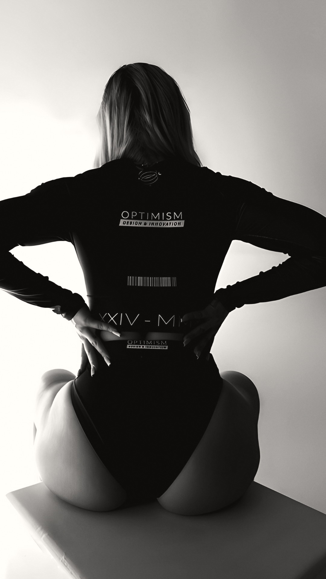OPTIMISM. archive — The reverse view. Light finds the wordmark and leaves the rest.